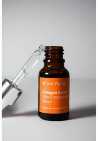 Brązowa butelka szklana z pomarańczową etykietą, srebrną nakrętką z pipetą, zawierająca przezroczysty serum. Tekst na etykiecie brzmi "Wzmacniacz kolagenu ultra skoncentrowany."