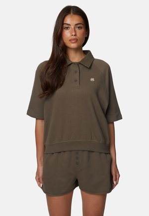 Top in cotone verde oliva stile polo con colletto, maniche corte e patta con bottoni. Abbinato a pantaloncini coordinati dallo stesso design.