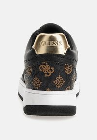 Sneaker nera con finitura strutturata, logo oro sul tallone e motivo logo color sabbia. Suola bianca con accenti neri. Design classico low-top.