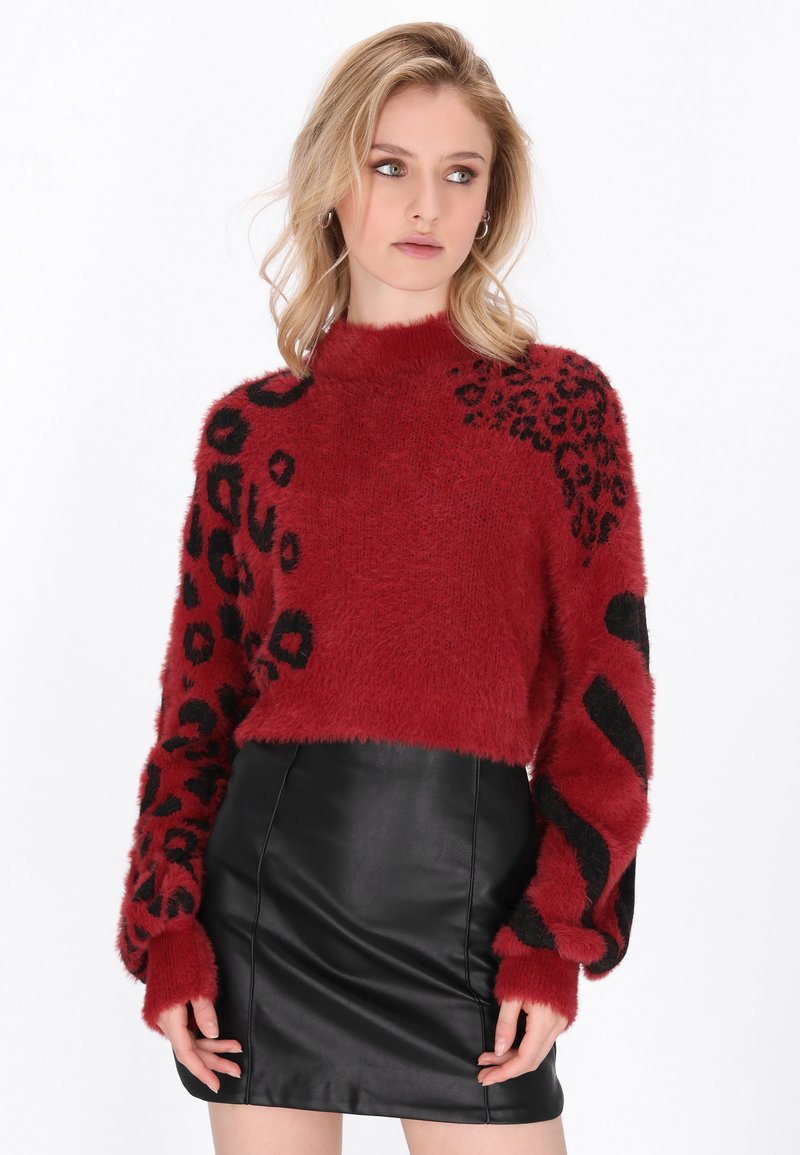 Rdeča puhasta sv sweatersica z black živalskim vzorcem in črtami na rokavih, v kombinaciji s črno krilom iz umetnega usnja.