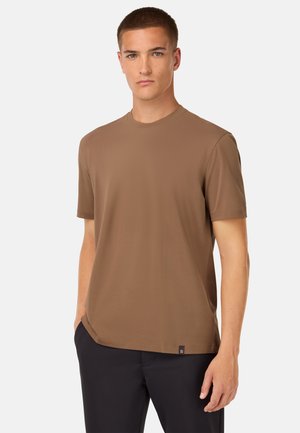 Camiseta de cuello redondo marrón, hecha de un tejido liso, de manga corta y corte recto, con una pequeña etiqueta de logo en el dobladillo.