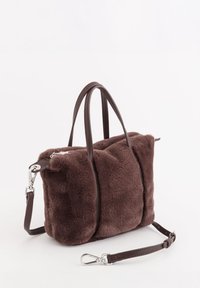 Sac à main en fausse fourrure marron avec deux poignées courtes et une bandoulière en cuir détachable. Présente une forme rectangulaire et des ferrures argentées.
