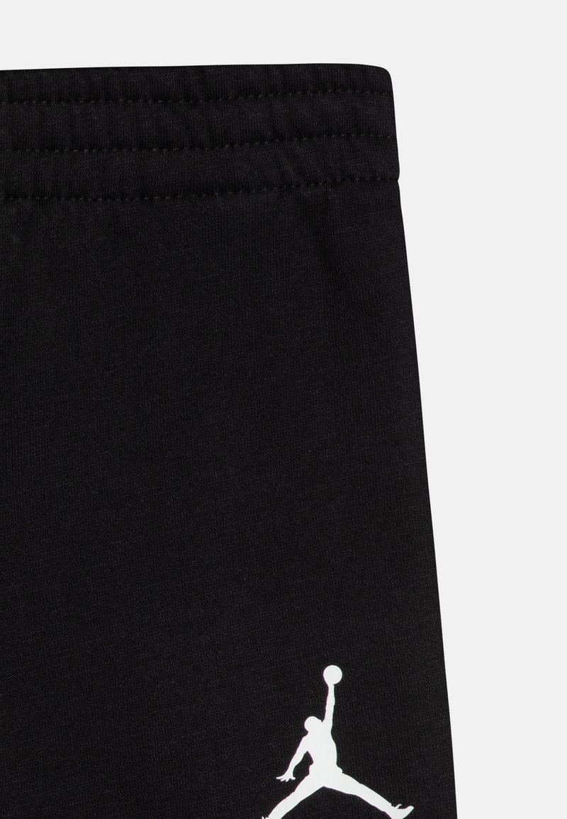 Pantaloni sportivi neri con vita elastica, caratterizzati da un logo Jordan bianco sul lato sinistro inferiore. Realizzati in morbido tessuto di cotone.