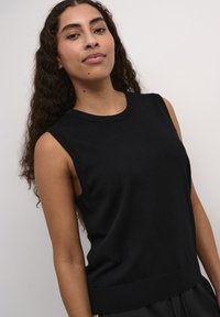 Zwarte mouwloze top van gebreide stof met een ronde halslijn, ribbelzoom en subtiele textuur. Ontworpen voor een aansluitende silhouet.