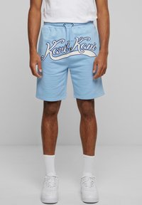 Light blue shorts made from cotton fabric, featuring a prominent white embroidered logo across the front and an adjustable waistband.