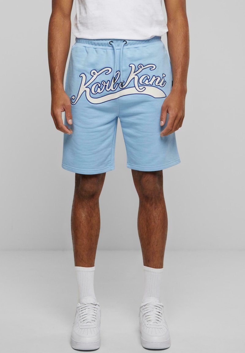 Light blue shorts made from cotton fabric, featuring a prominent white embroidered logo across the front and an adjustable waistband.