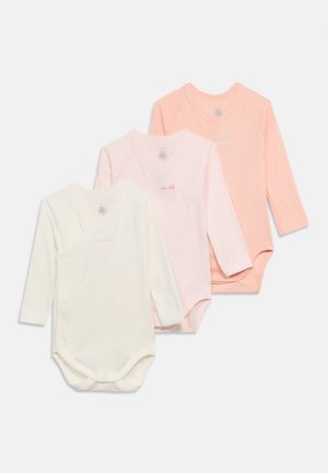 Három hosszú ujjú bababody krémszínben, világos rózsaszínben és őszibarackszínben, oldalsó patentokkal, fehér háttéren egymásra helyezve.