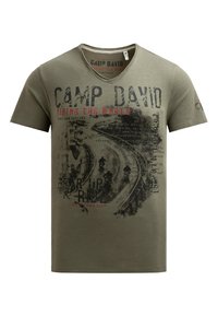 Khaki cotton t-shirt with a v-neck, featuring red and black graphic text: "CAMP DAVID" and "RIDING THE WORLD," with motorcycle imagery.