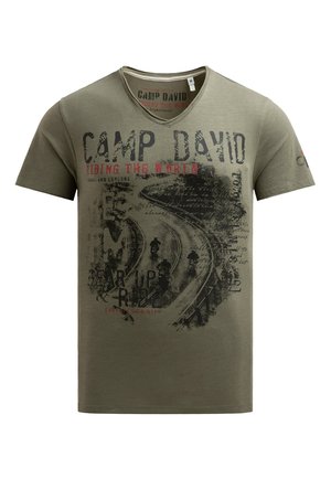 Khaki cotton t-shirt with a v-neck, featuring red and black graphic text: "CAMP DAVID" and "RIDING THE WORLD," with motorcycle imagery.