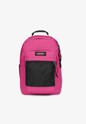 Mochila rosa con bolsillo frontal de malla negra. Cuenta con un asa superior, correas ajustables y un parche de logo de marca. Exterior de tejido suave.