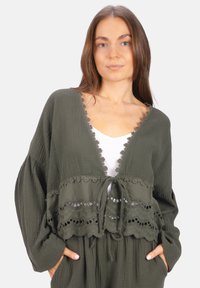 Olivengrüner, leichter, kurzer Cardigan mit Spitzendetails, V-Ausschnitt, Bindeschluss und langen Ärmeln. Strukturiertel Stoff mit lockerer Passform.