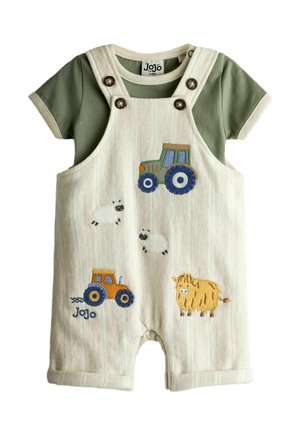 Salopette beige per bambini piccoli con maglietta verde a maniche corte, decorata con trattori ricamati, pecore e una mucca Highland gialla.