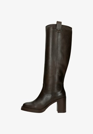 Stivale marrone in pelle fino al ginocchio con punta quadrata, tacco a blocco e dettagli di cucitura. Include un tassello posteriore per indossarlo facilmente.