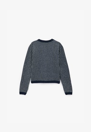 Maglione a maglia blu navy con righe verticali bianche, scollatura arrotondata e polsini a costine. Presenta un motivo testurizzato su tutta la superfice.