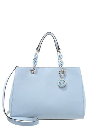 Bolso de cuero azul claro con dos asas que presentan eslabones de cadena plateados y azules, una correa desmontable para el hombro y un colgante redondo con el logo MK en plata.