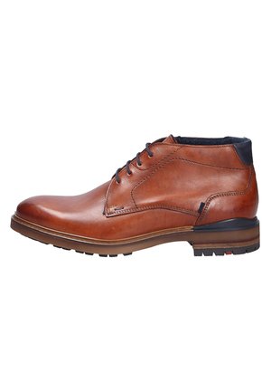 Bottines en cuir marron à bout arrondi, avec des accents cousus, un système de laçage et un talon foncé contrastant. Semelle en caoutchouc durable.