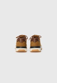 Brown suede sneakers with leather accents, black midsole, and gum rubber outsole. Features rounded heel and lace-up closure.