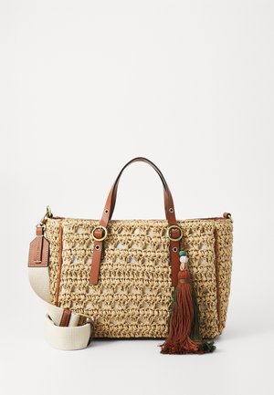 Sac à main rectangulaire en paille tressée avec des poignées en cuir marron, une bandoulière réglable crème et un charm pompon décoratif orange et vert.