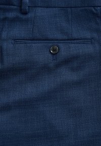 Marineblaue Hosen aus strukturiertem Stoff, mit einer Vordertasche und einem schwarzen Knopf. Der Stoff zeigt ein dezentes Muster und ist glatt.
