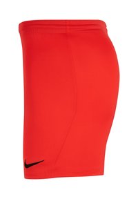 Shorts de sport rouges fabriqués à partir d'un matériau lisse et léger, dotés d'un design ajusté, de coutures latérales et d'un logo Nike noir en bas à gauche.