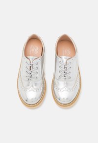 Scarpe stringate in argento metallizzato con bordi scallopati, una finitura liscia e una suola in gomma beige. Progettate per un look classico con un tocco moderno.