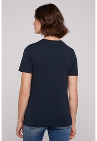 T-shirt bleu marine à manches courtes en coton, avec un col rond et une coupe décontractée, coutures visibles près de l'ourlet et des manches.