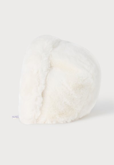 Chapeau blanc doux et pelucheux avec un bord replié, présenté sur un fond clair uni.