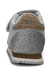 Sneaker azzurro chiaro con tacco in glitter argento, dettagli in pelle marrone texturizzata e una chiusura in velcro. Presenta una suola in gomma con un design a pattern.