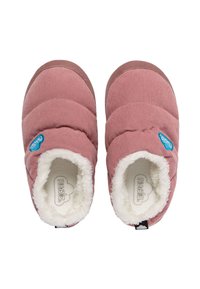 Zapatillas rosa pálido con parte superior de tela acolchada, suave forro de piel sintética blanca, suela de goma marrón y logotipo azul en el lateral.