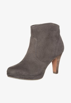 Bottine en suède gris avec un bout légèrement arrondi, un talon haut et des accents de couture blanche. Présente une texture lisse et un design structuré.