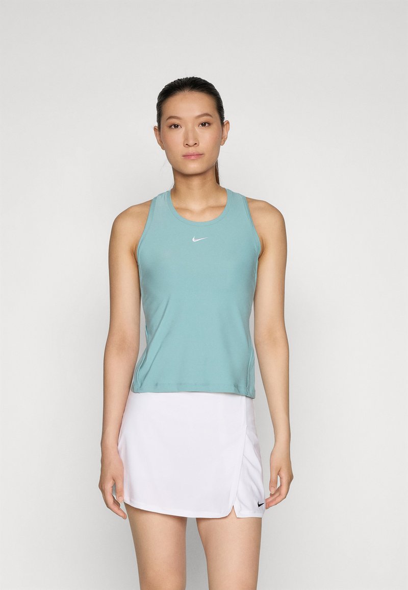 Helles teal-farbenes Sporttanktop mit Rundhalsausschnitt und Racerback-Design, kombiniert mit einem weißen Faltenrock, der auf beiden Teilen ein Nike-Logo trägt.