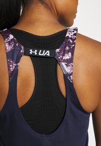 Granatowy sportowy tank top z czarną siateczką i fioletowymi paskami w wzór, z logo UA na plecach. Zaprojektowany dla wygody i oddychalności.