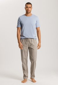 Lichtblauw T-shirt met korte mouwen gecombineerd met gestreepte pyjamabroek in beige, blauw en bruin tinten, met een elastische tailleband en trekkoord.
