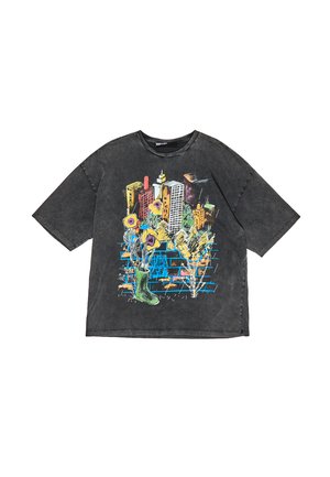Zwarte oversized t-shirt met een kleurrafische afbeelding van gebouwen, bloemen en een groene laars. Lichte slijtage voegt textuur toe.