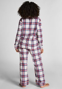 Geruite flanellen pyjamabroekset in wit, rood en blauw. Hemd met lange mouwen en een relaxte pasvorm met een geblokt patroon en een zachte textuur.