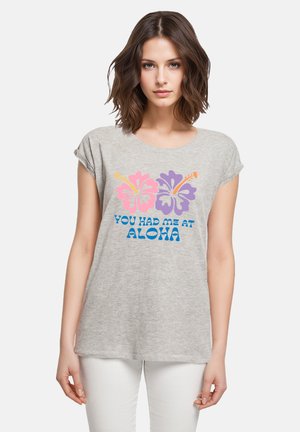 Gray cotton t-shirt with short sleeves. Features pink and purple hibiscus flowers and the phrase "YOU HAD ME AT ALOHA" in blue text.