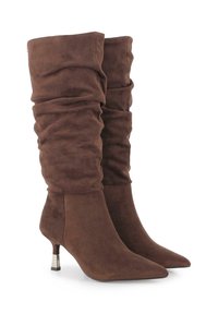 Botas de ante marrón hasta la rodilla con un diseño arrugado, puntera afilada y un acento de tacón metálico. Textura suave y acabado blando.