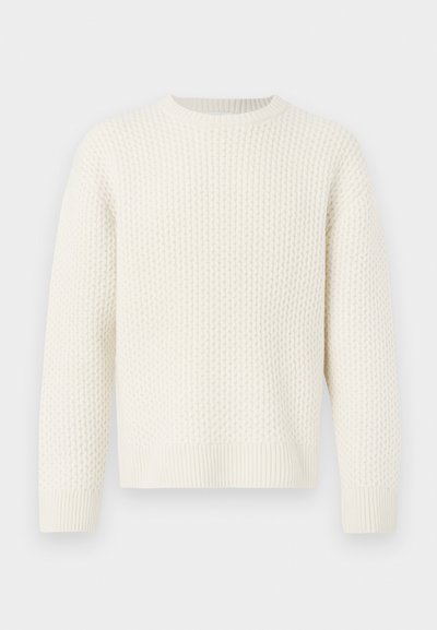 Suéter blanco de punto con un patrón texturizado, cuello redondo, hombros caídos y puños y dobladillo de canalé. Corte relajado.