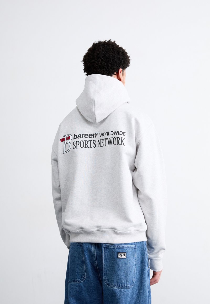 Grå hættebluse med snører og et stort grafisk tryk i sort og rød, der står "bareen WORLDWIDE SPORTS NETWORK" på ryggen.
