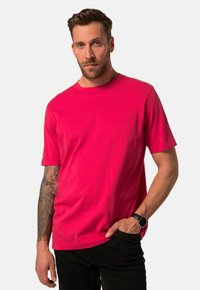 Gez fitted T-shirt met korte mouwen in felroze katoen, met een ronde hals. Het heeft een zachte textuur en een minimalistisch ontwerp, gecombineerd met zwarte broeken.