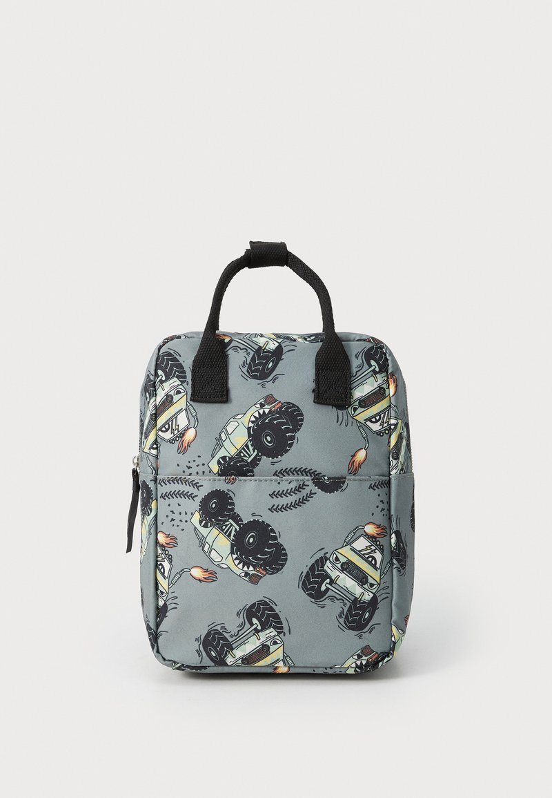 Grå stoffryggsekk med et gjentatt mønster av tegneserie monstertrucker, med svarte detaljer og et håndtak på toppen for enkel bæring.