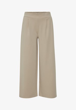 Beżowe spodnie o szerokich nogawkach z elastyczną talią, z przednimi zaszewkami, miękką teksturą i luźnym krojem.