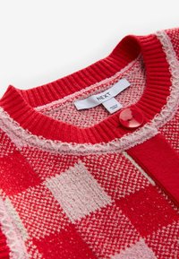 Czerwony i różowy sweter z dzianiny w kratkę, ze ściągaczem na kołnierzu, dekoracyjnymi przeszyciami, jednym czerwonym guzikiem i metką marki "NEXT".