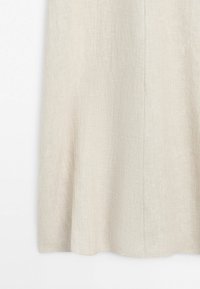 Spódnica z teksturowanego lnu w kolorze ecru o lekkim rozkloszowanym kroju, wisząca na jednolitym białym tle.