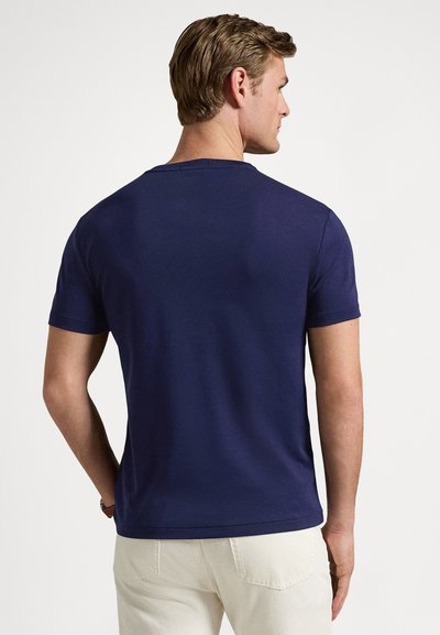 Maglietta in cotone blu navy con scollo rotondo e maniche corte. La parte posteriore presenta una texture liscia senza disegni o grafiche visibili.