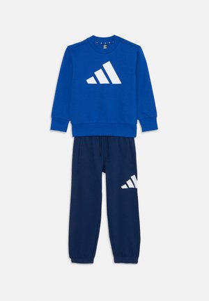 Blaues Sweatshirt mit einem weißen Adidas-Logo, kombiniert mit navyblauen Jogginghosen mit einem weißen Logo. Weicher Stoff, lockere Passform, elastische Bündchen.