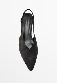 Svart mocka slingback-sko med spetsig tå, med en utskuren design och en silverfärgad spänneffekt på remmen vid vristen.