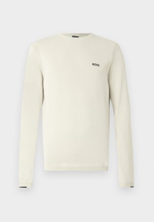 Hellbeiger Pullover mit langen Ärmeln, rundem Ausschnitt, gerippten Bündchen und kleinem schwarzem "BOSS"-Logo auf der Brust. Glatte Textur, lässiges Design.