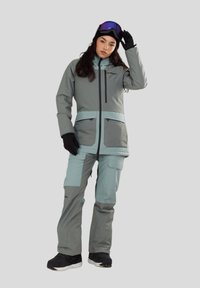 Snowboardpak in grijs en lichtblauw, met een rits aan de voorkant, meerdere zakken en een aansluitend ontwerp met lange mouwen en broeken.