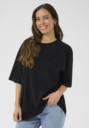 T-shirt nero oversize in morbido cotone, con scollatura rotonda e maniche corte, caratterizzato da un discreto logo sul petto.